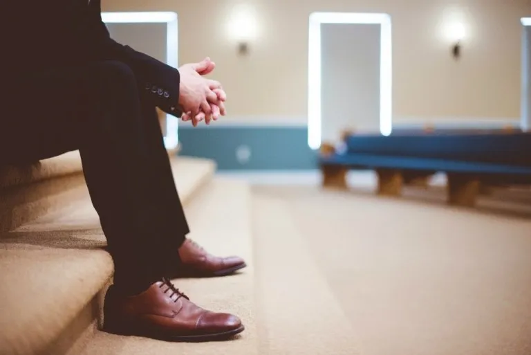 Una donna seduta in attesa che simboleggia la paura di essere feriti e la solitudine nelle relazioni