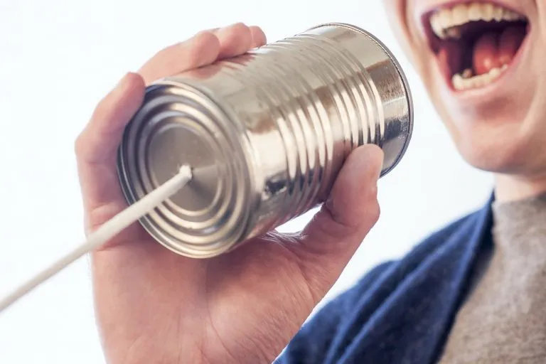 Due vecchi telefoni a barattolo che simboleggiano la differenza tra relazione e comunicazione