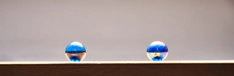 Biglie di vetro colorate su fondo marmoreo che simboleggiano i diversi piani dell'ecosistema di vita per l'autorealizzazione personale