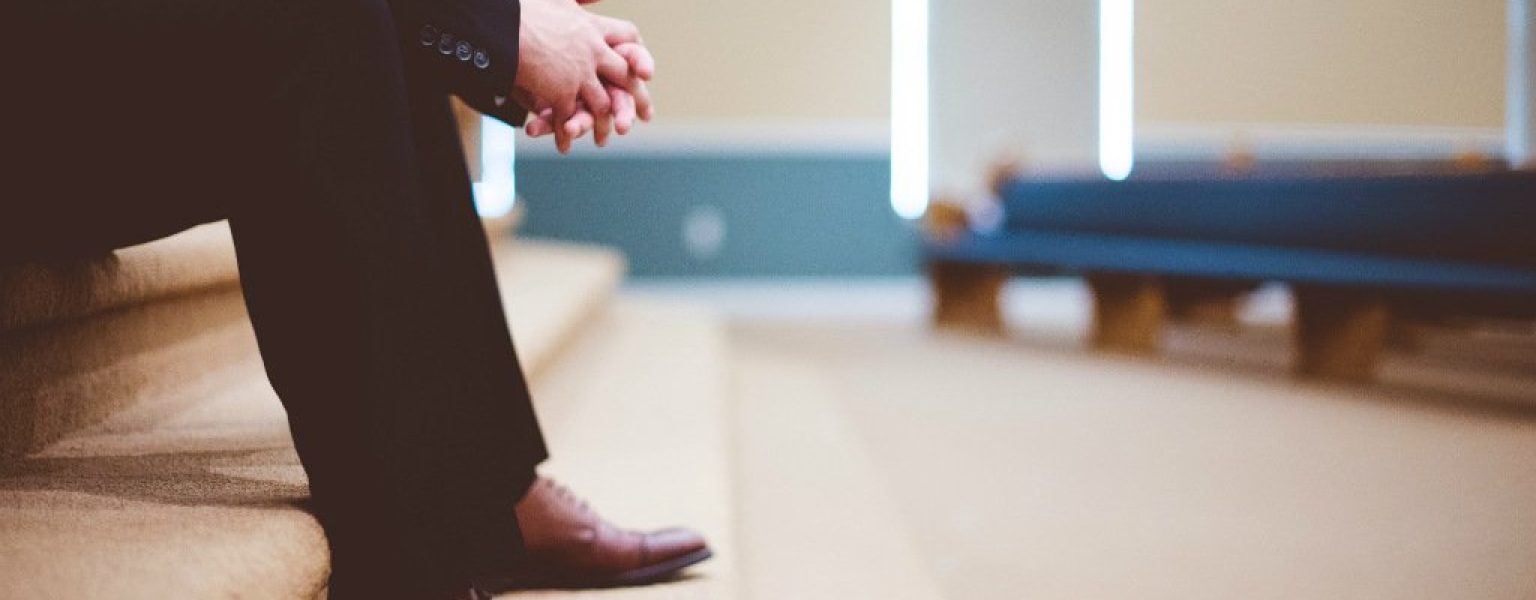 Una donna seduta in attesa che simboleggia la paura di essere feriti e la solitudine nelle relazioni